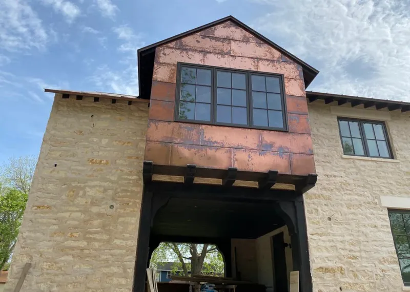 Copper metal panel facade on a stone building for Roof Repair in Belen